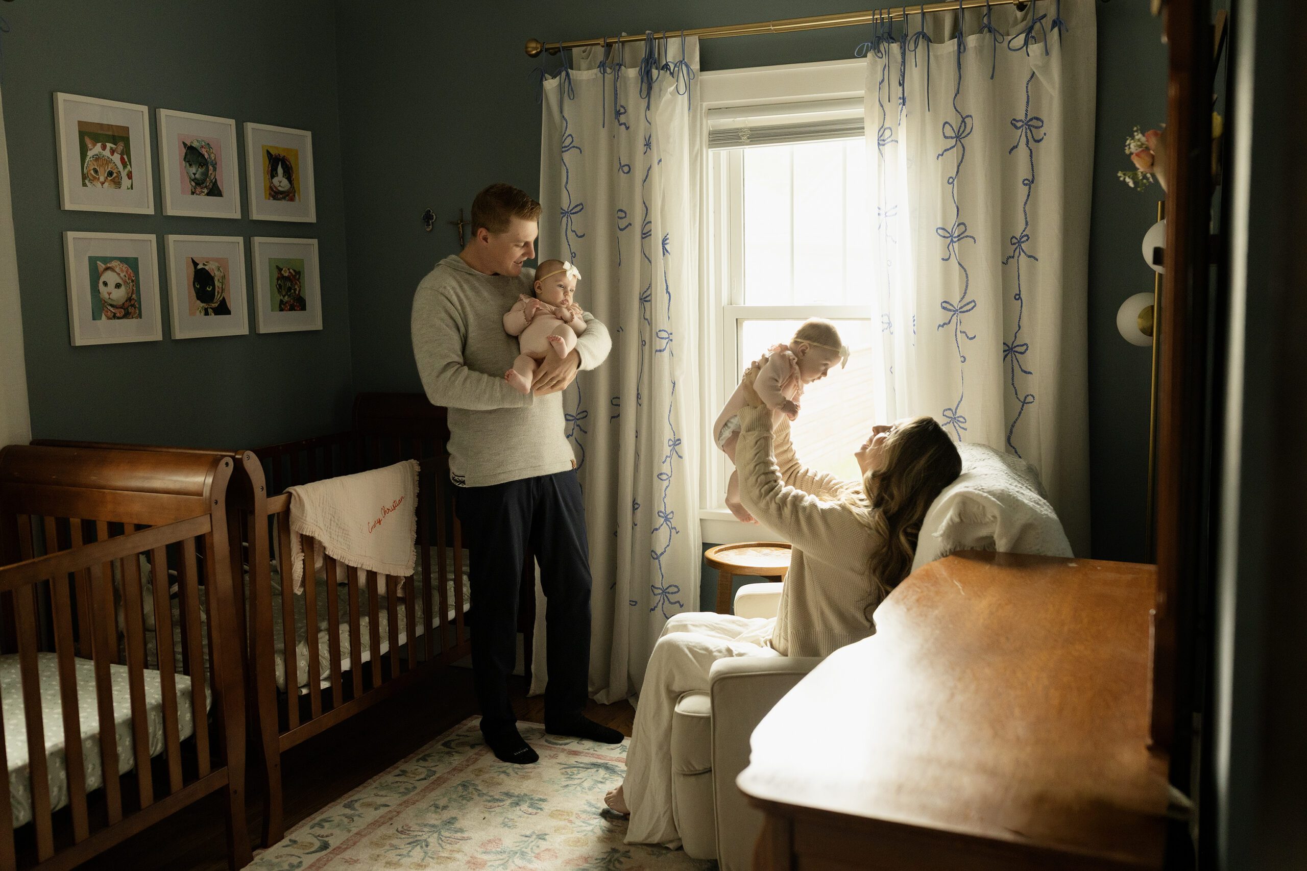 St Paul mom and dad play with their newborn daughters in the nursery during a newborn session