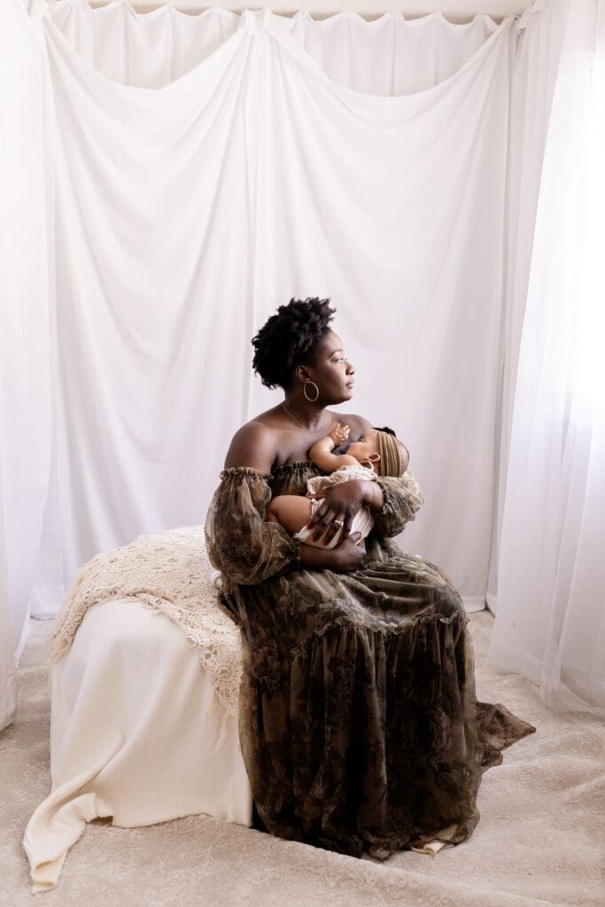 New mom holding her 6 month old baby during a motherhood session with a Lindstrom photographer at a studio