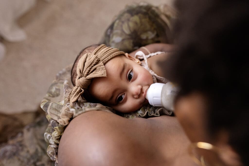 6 month old being fed a bottle during a motherhood and milestone photo session near Lindstrom, MN